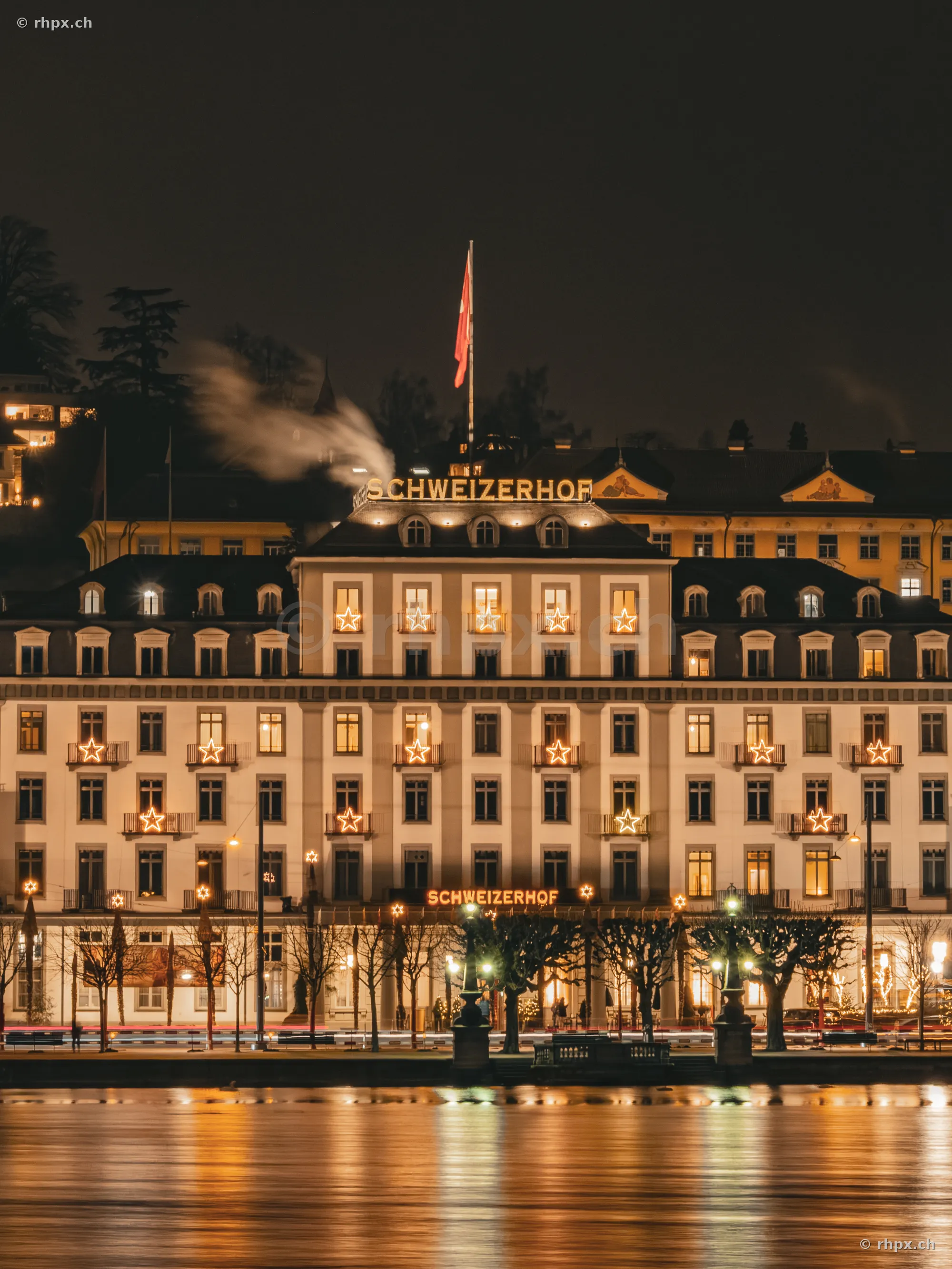 The festively illuminated Hotel Schweizerhof Lucerne at night
