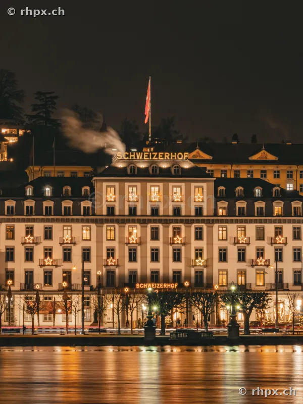 The festively illuminated Hotel Schweizerhof Lucerne at night
