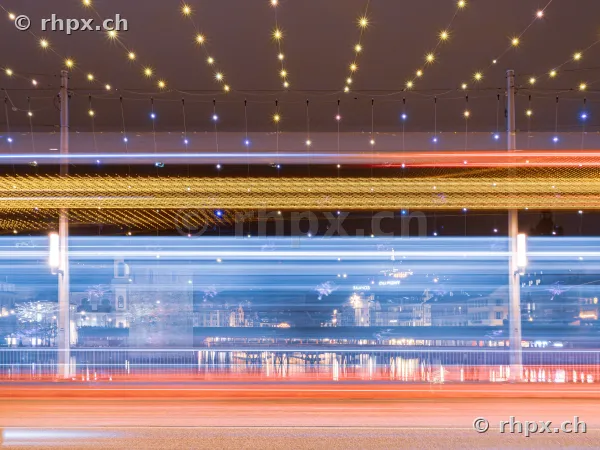Long exposure of vehicle light trails in front of the festive illuminated scenery of Lucerne city at the lake