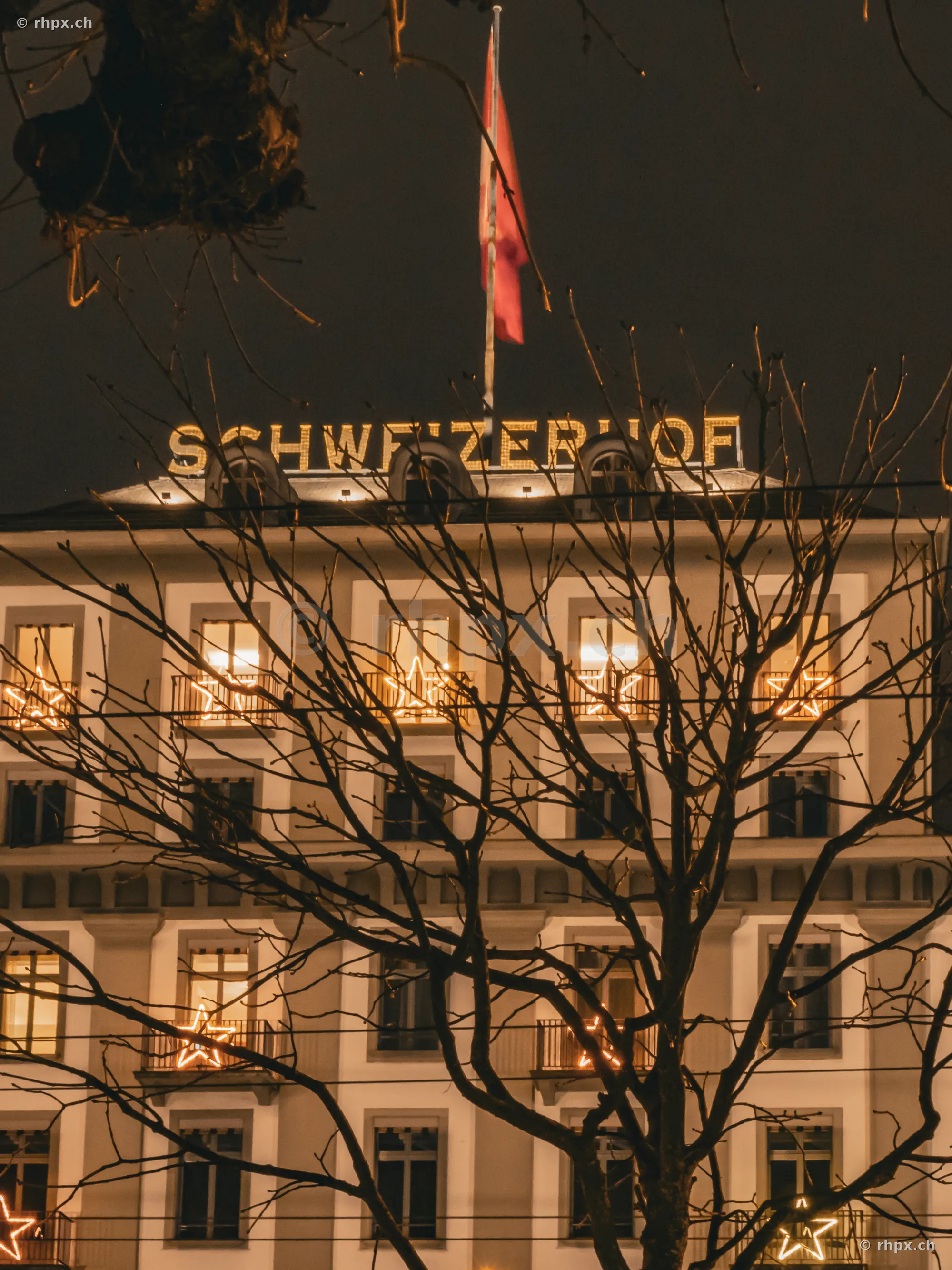 Fassade des Hotels Schweizerhof in Luzern mit Weihnachtsbeleuchtung bei Nacht