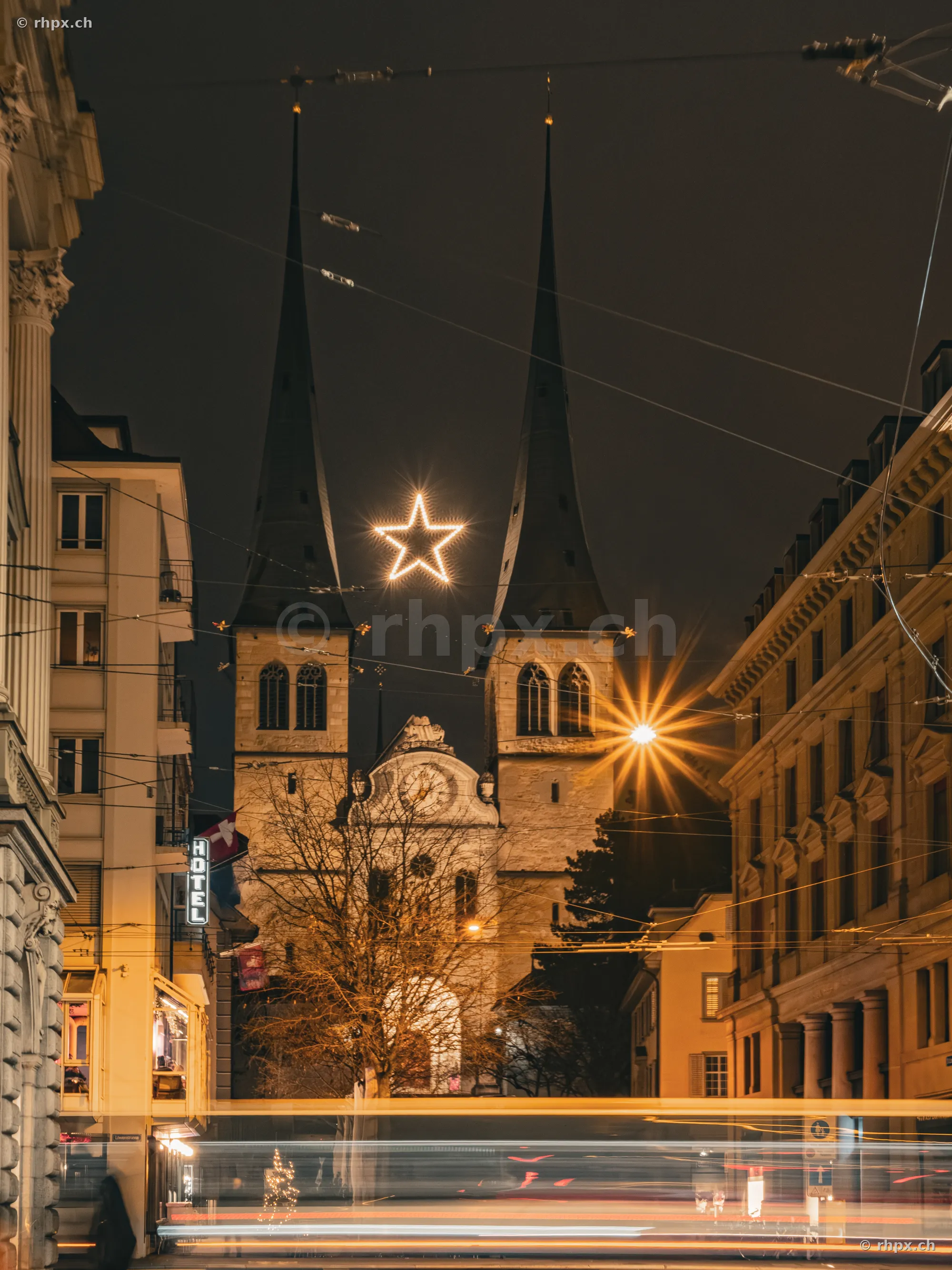 Hofkirche in Luzern mit beleuchtetem Stern zwischen den Türmen bei Nacht