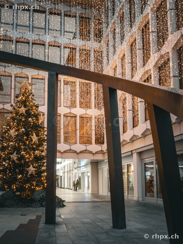 Illuminated Christmas tree and fairy lights on a building facade in a Lucerne courtyard