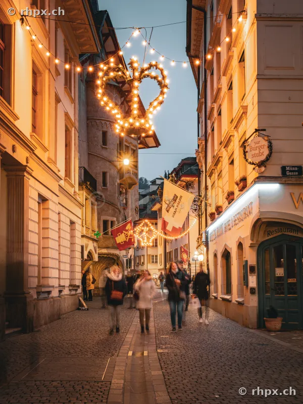 People walking along the festively illuminated Münzgasse in Lucerne during Christmas time