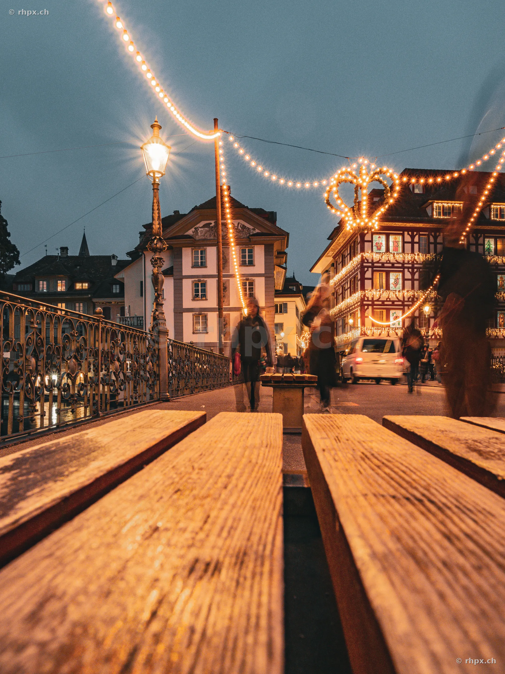 Holzbank in der Altstadt von Luzern mit weihnachtlicher Beleuchtung am Abend