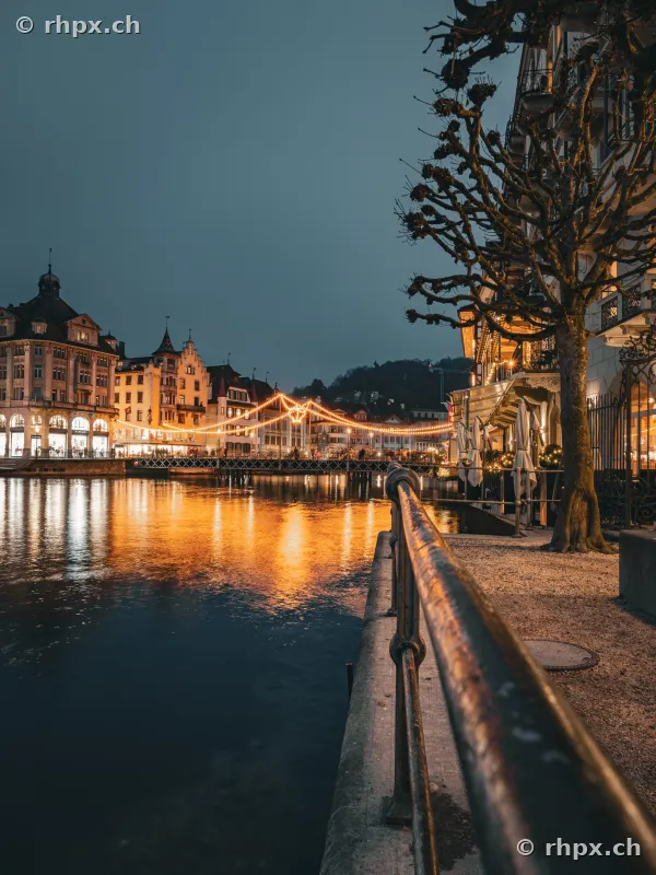 View across the Reuss towards the illuminated riverside of Lucerne during the Christmas season