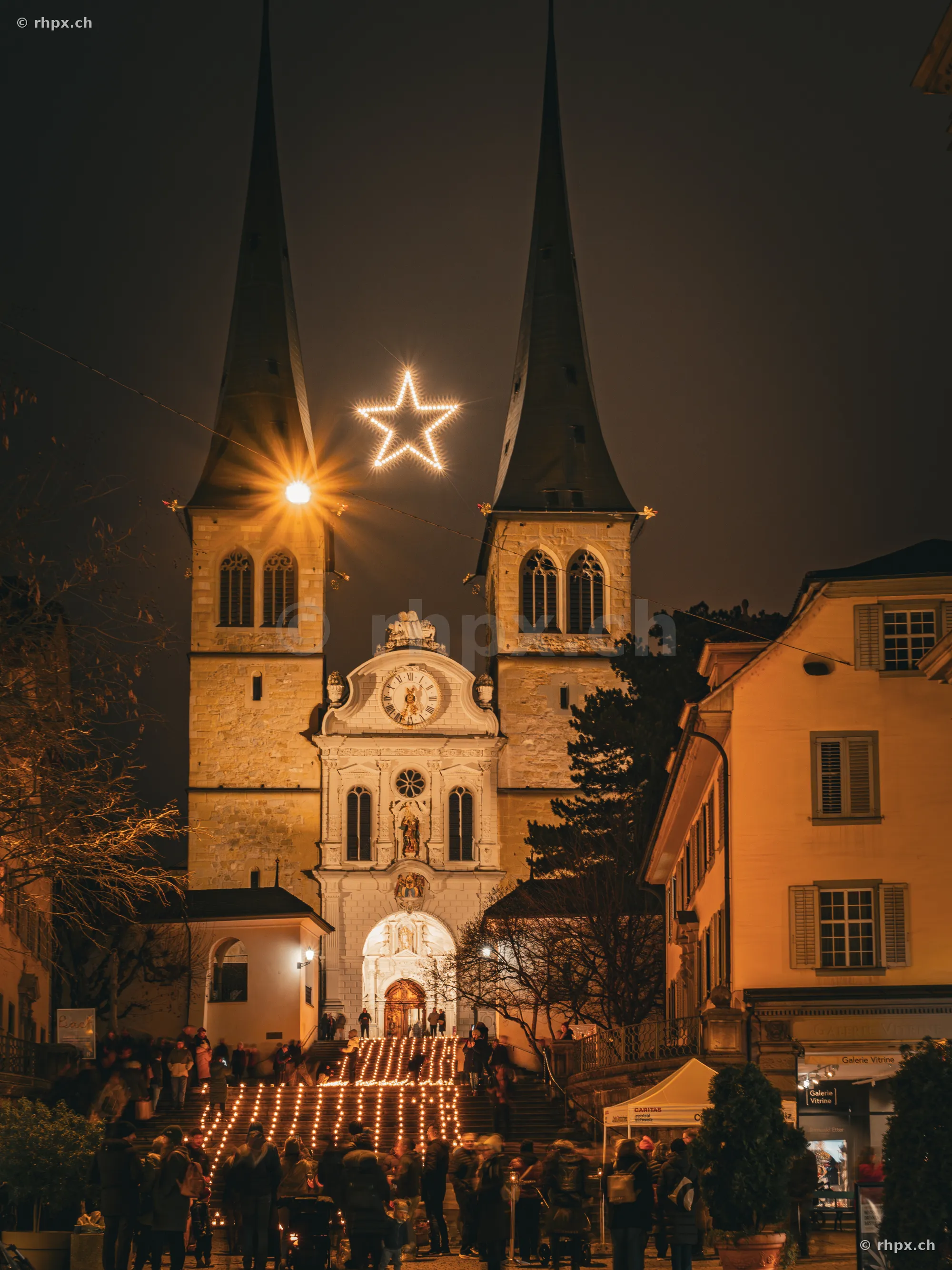 Hofkirche Luzern mit Weihnachtsstern und Lichtertreppe bei Nacht