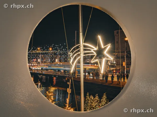 View through a round window of festive Christmas lighting in Lucerne