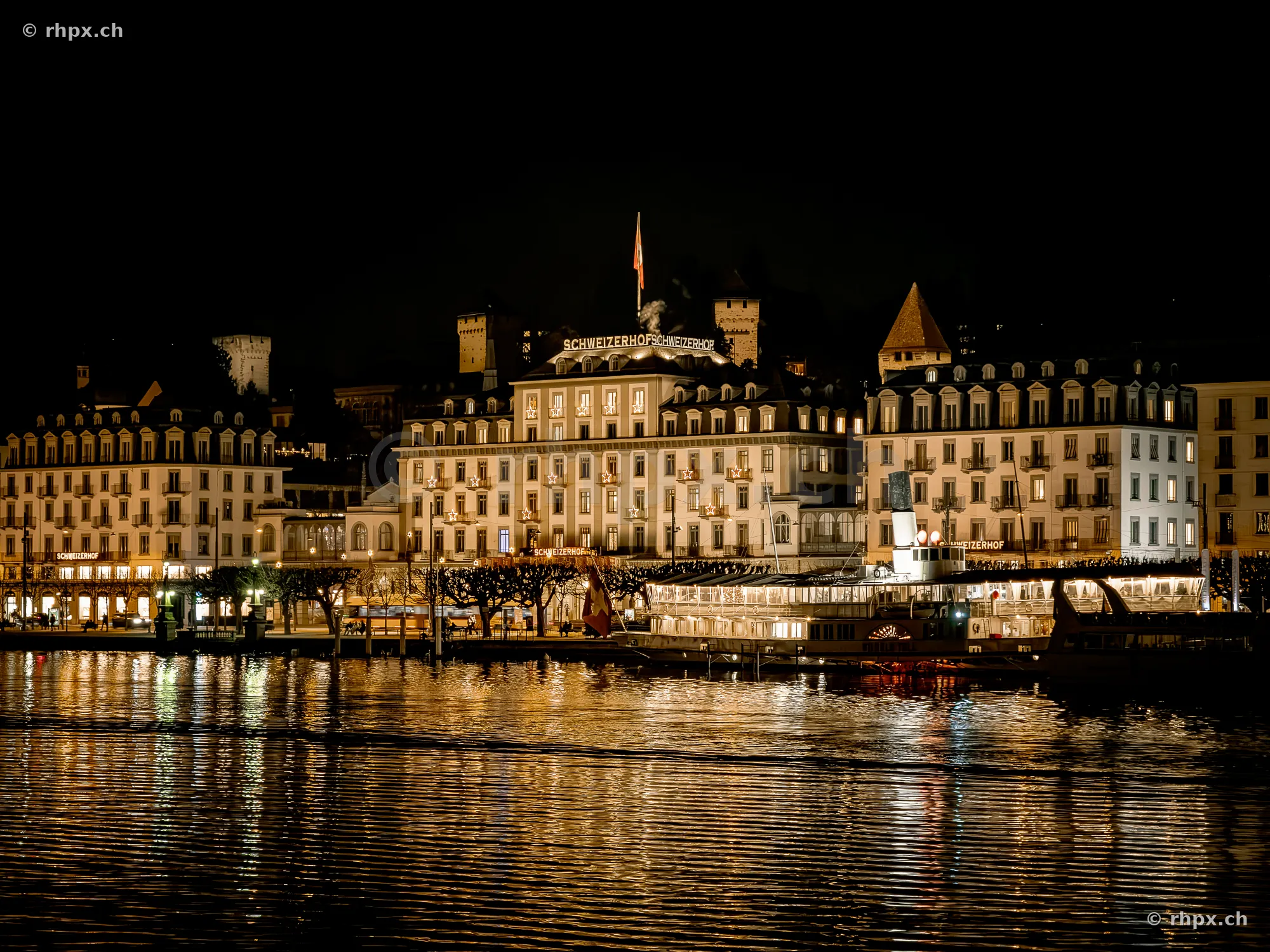 Beleuchtete Fassade des Hotels Schweizerhof in Luzern bei Nacht