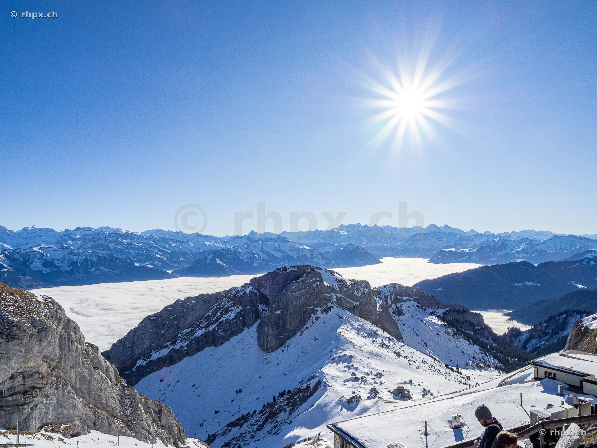 Verschneite Gipfelregion am Pilatus mit Blick auf das unterliegende Nebelmeer bei hellem Sonnenschein