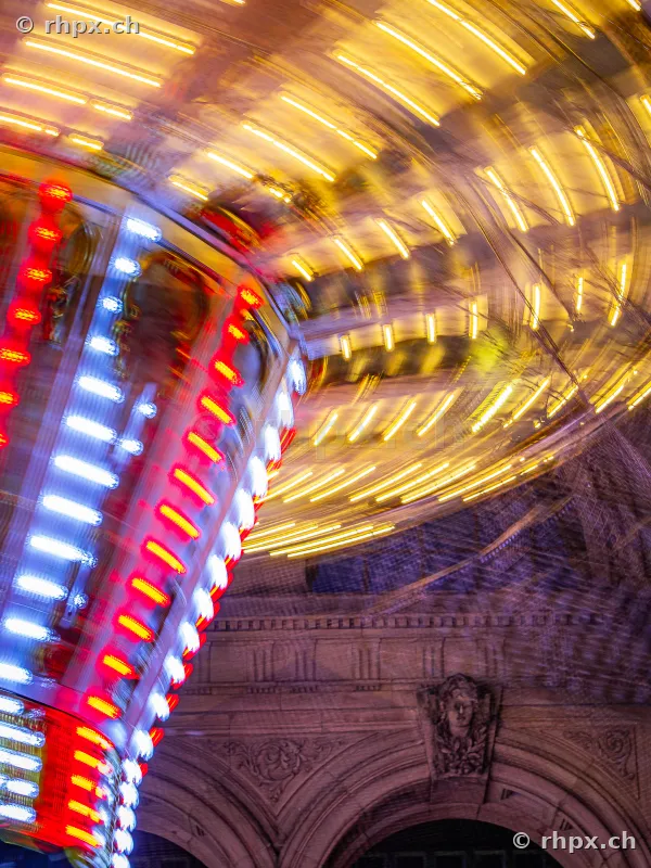 Long exposure of a spinning carousel at night at the Lucerne Autumn Fair