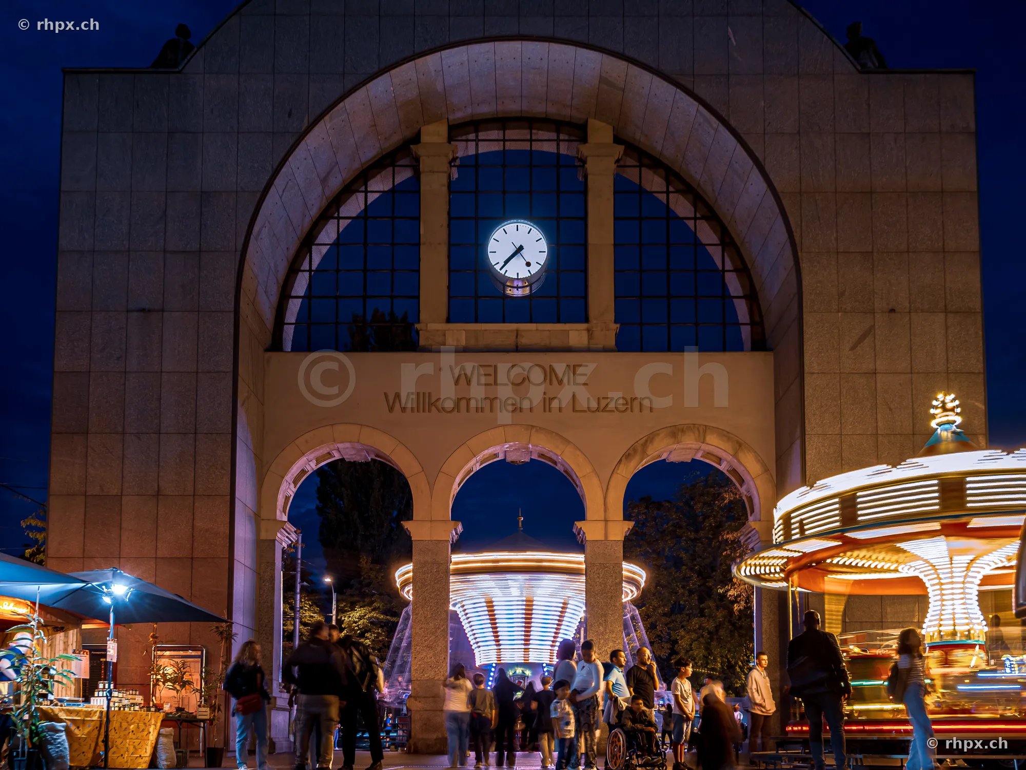 Lucerne station gate at night with autumn fair carousel