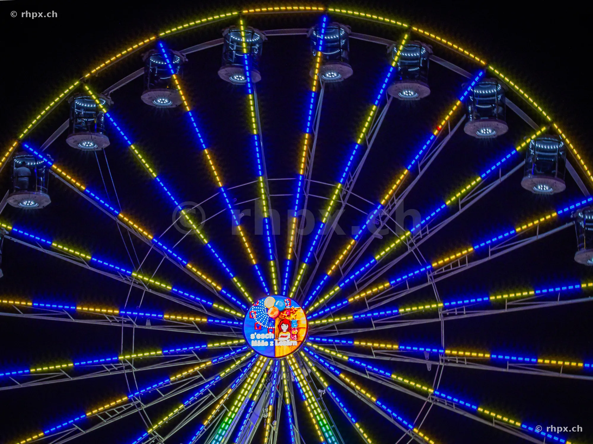 Illuminated Ferris wheel at the Lucerne autumn fair at night