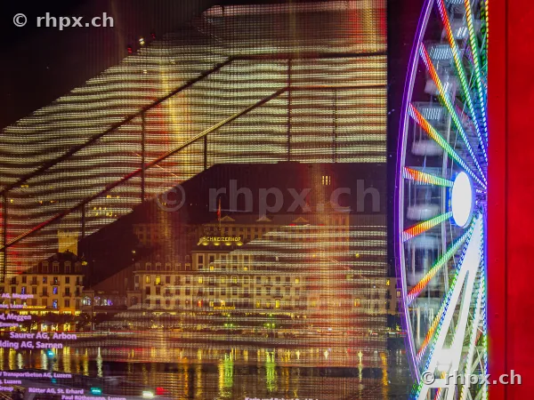 Ferris wheel of the Lucerne autumn fair in front of the KKL facade at night
