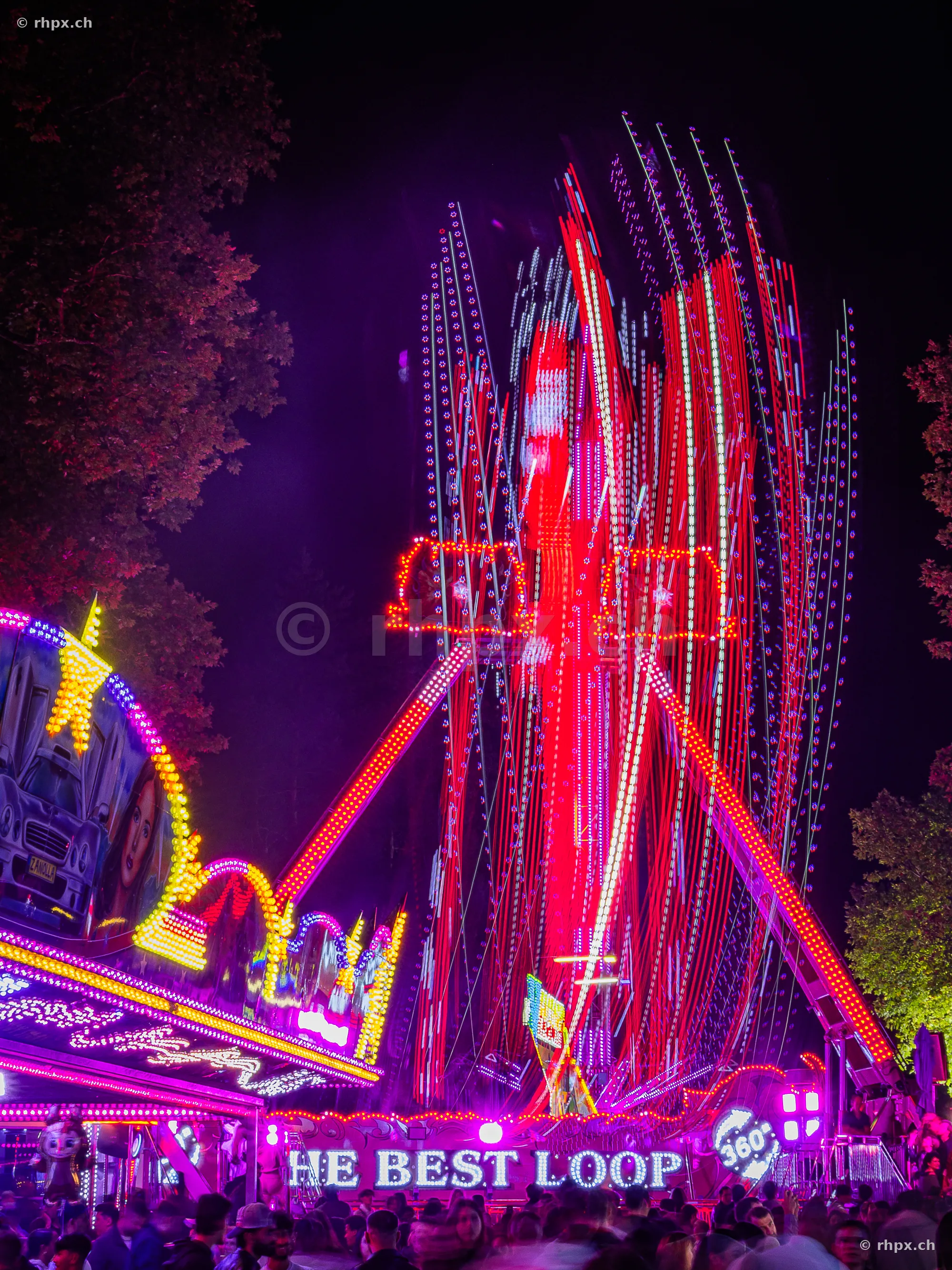 Illuminated fairground ride at night at the Lucerne Autumn Fair