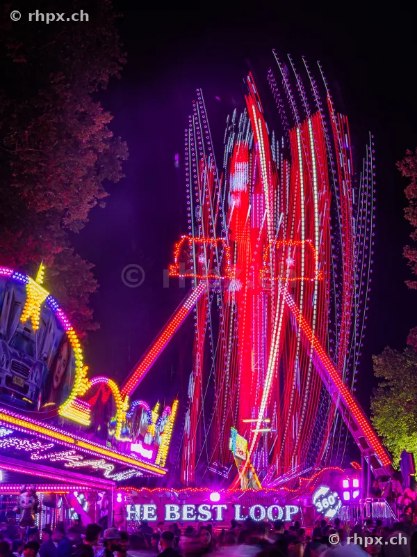 Illuminated fairground ride at night at the Lucerne Autumn Fair