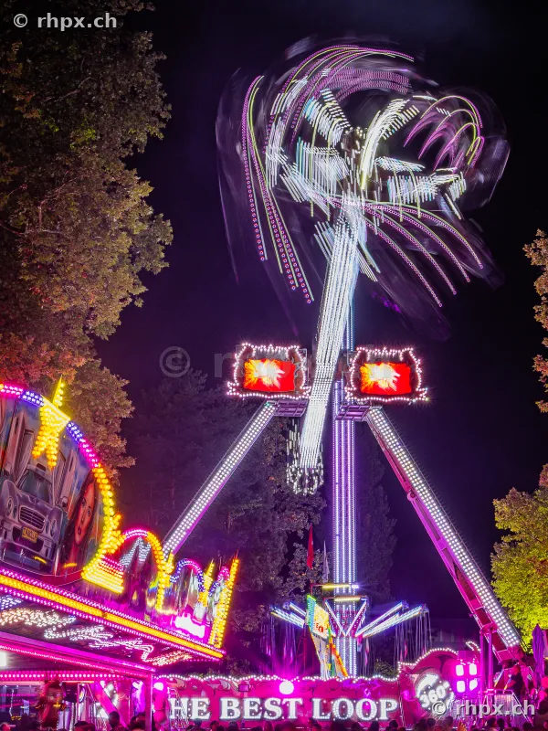 Long exposure of an illuminated fairground ride at the Lucerne autumn fair at night