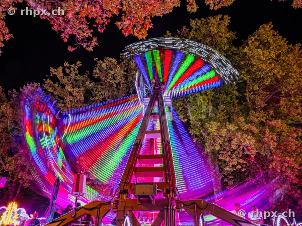 Illuminated fairground ride at the Lucerne autumn fair at night