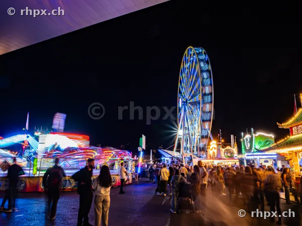 Riesenrad und Fahrgeschäfte bei Nacht auf dem Messegelände der Lozärner Määs