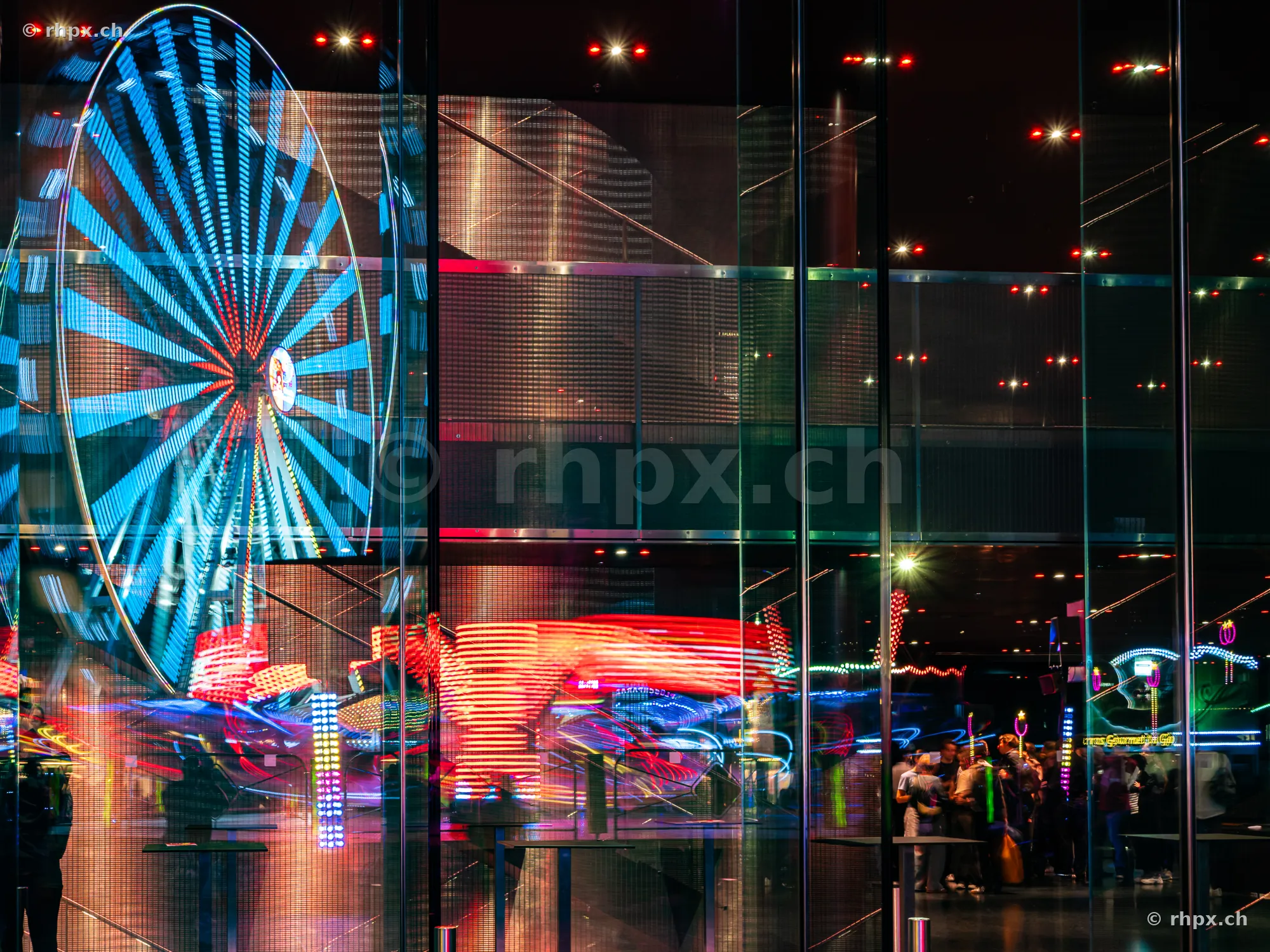 Reflection of the Lozärner Määs in a glass facade at night