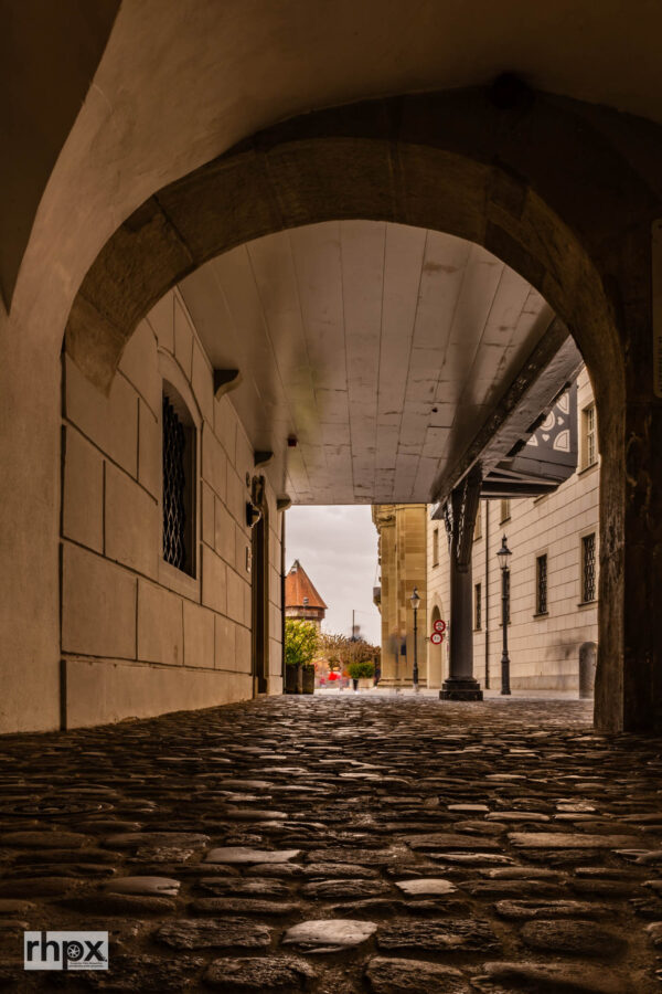 Luzerner Altstadtgasse mit Blick auf einen historischen Turm und markierte Strassenlinien im Vordergrund.