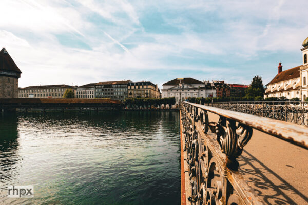Der Rathaussteg bietet einen klaren Blick über die Reuss zur Kapellbrücke, zum Wasserturm und zur Jesuitenkirche. Im Sommer ist der Standort besonders am Abend interessant, wenn das Licht flach über die Stadt fällt.